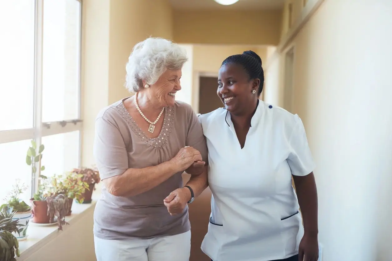 A woman and an older person are smiling together.